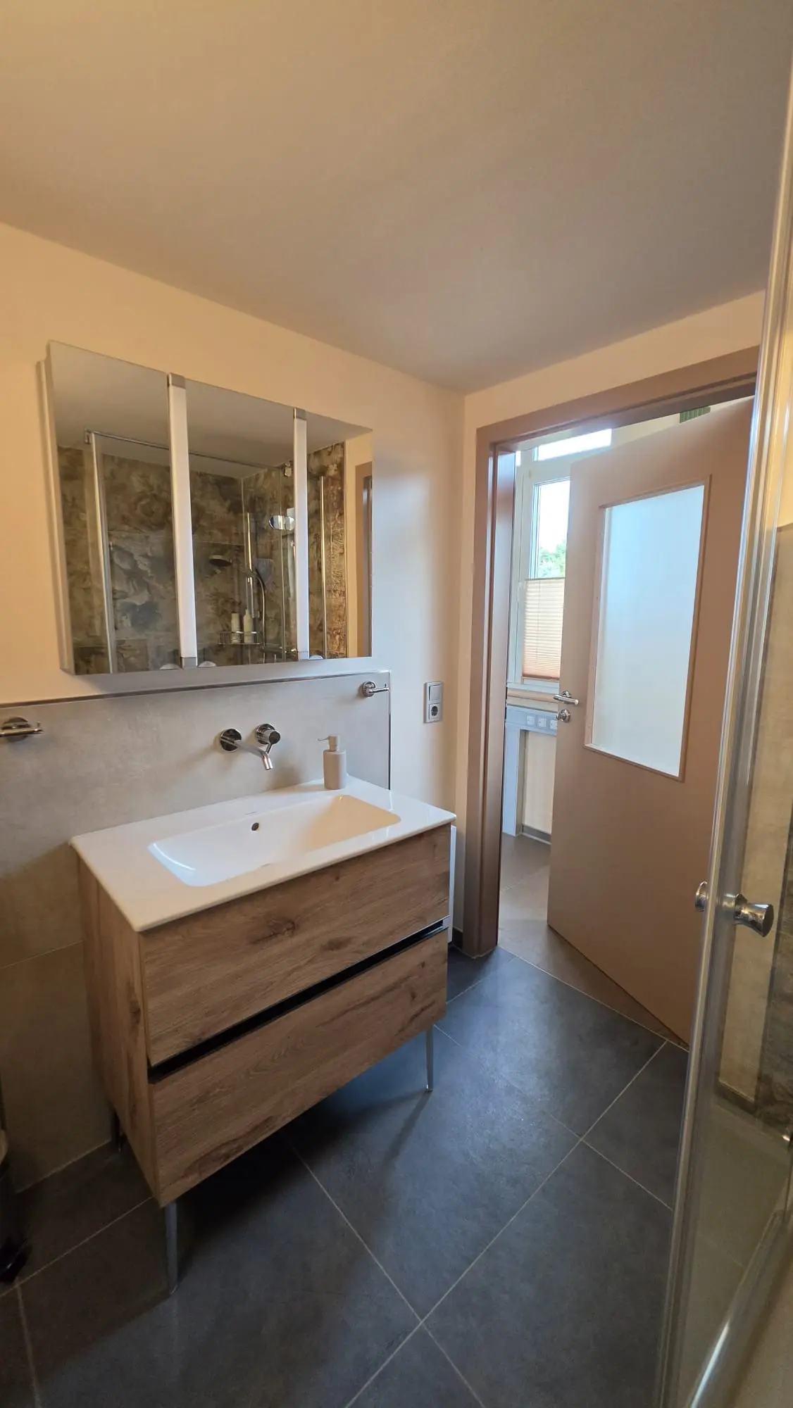 Badezimmer mit Waschtisch und Spiegelschrank