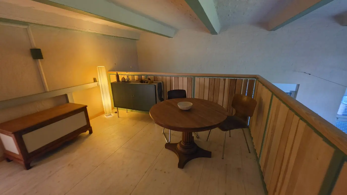 Sitzplatz auf der Galerieebene der Ferienwohnung Zahna-Loft — runder Tisch mit zwei Stühlen und Stehleuchte