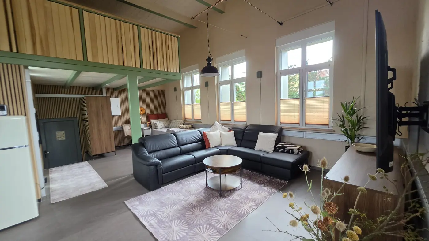 Wohnzimmer mit schwarzer Relax-Ledercouch