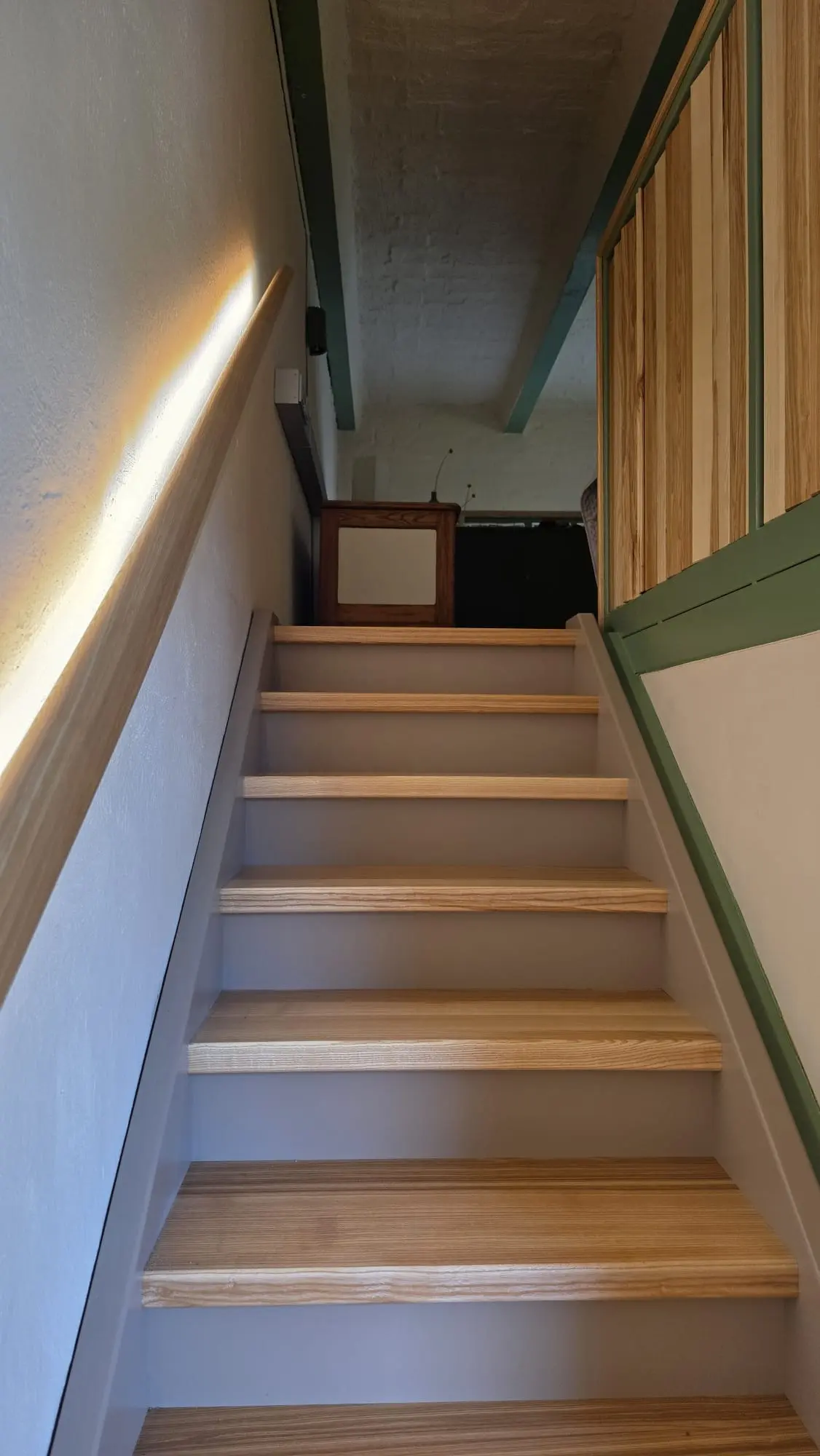 Holztreppe, die vom Wohnbereich hinauf zur Schlafgalerie führt